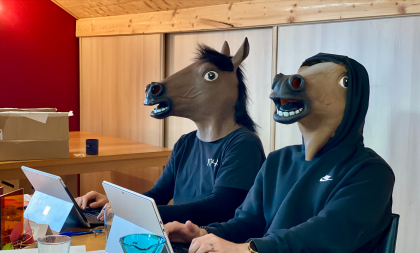 Deux chevaux (humains à masque de cheval) ravaillent à l'ordinateur